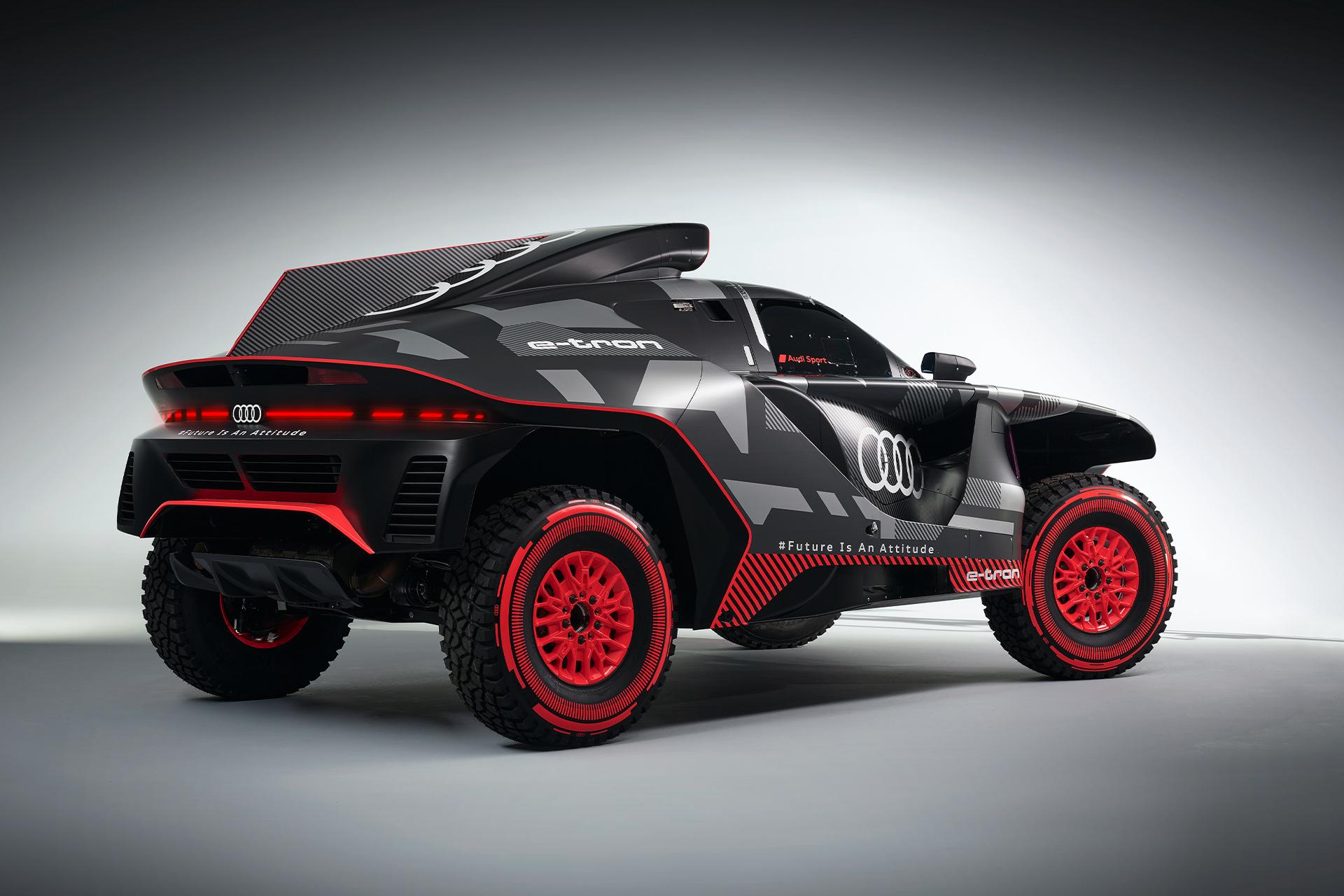 A side shot of the black-and-red Audi RS Q e-tron{ft_rs-q-e-tron}, in which the red rims and details in the tires are visible.